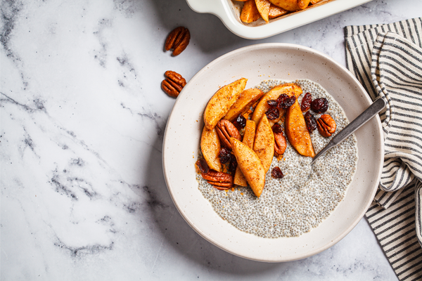 Chia pudding with caramelized apples, cinnamon, pecan and cranberries, top view. Winter vegan breakfast recipe.