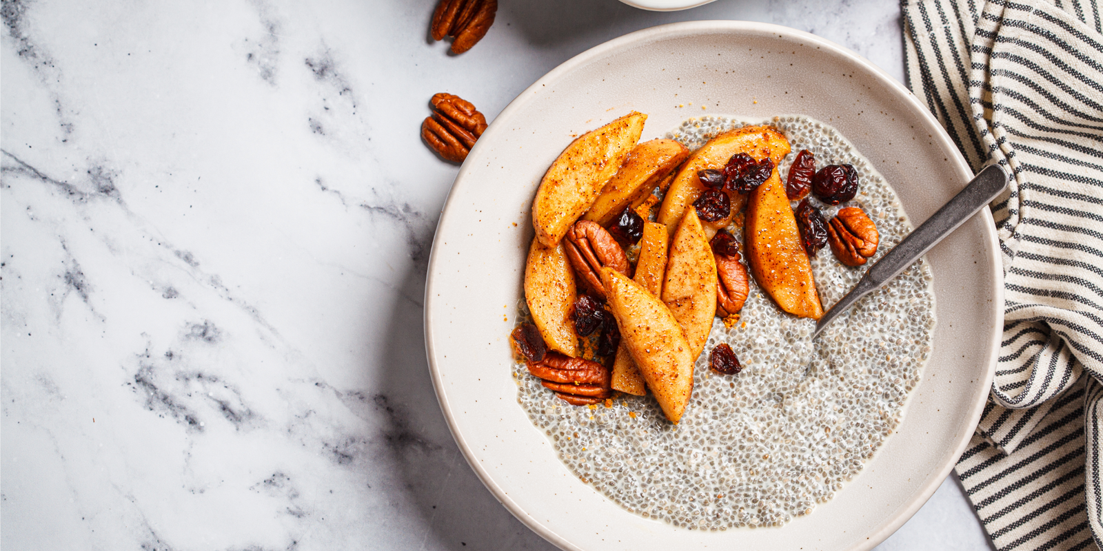 Chia pudding with caramelized apples, cinnamon, pecan and cranberries, top view. Winter vegan breakfast recipe.