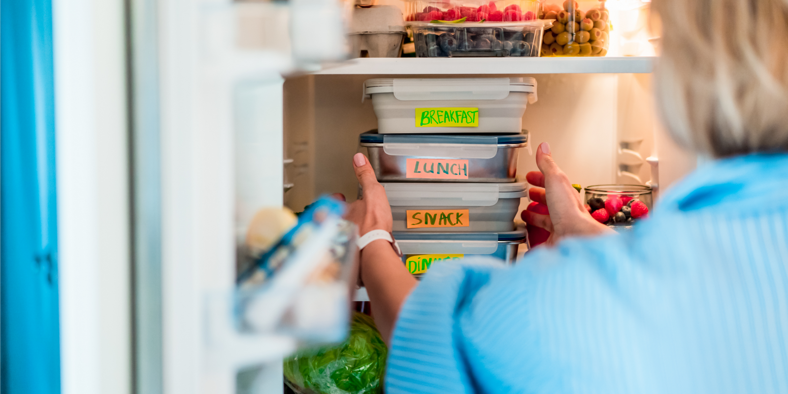 Healthy diet plan for weight loss, daily ready meal menu. Woman taking or putting lunch boxes cooked in advance, ready to be served into the fridge. 