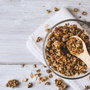 Homemade granola in a glass bowl on a white wooden table