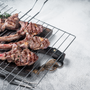 Barbecue grilled lamb meat chop on a grill, mutton rib cutlet. White background. Top view. Copy space.