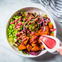 Vegan salad bowl with baked sweet potatoes, edamame beans, nuts and pink beetroot dressing. Vegan food concept.