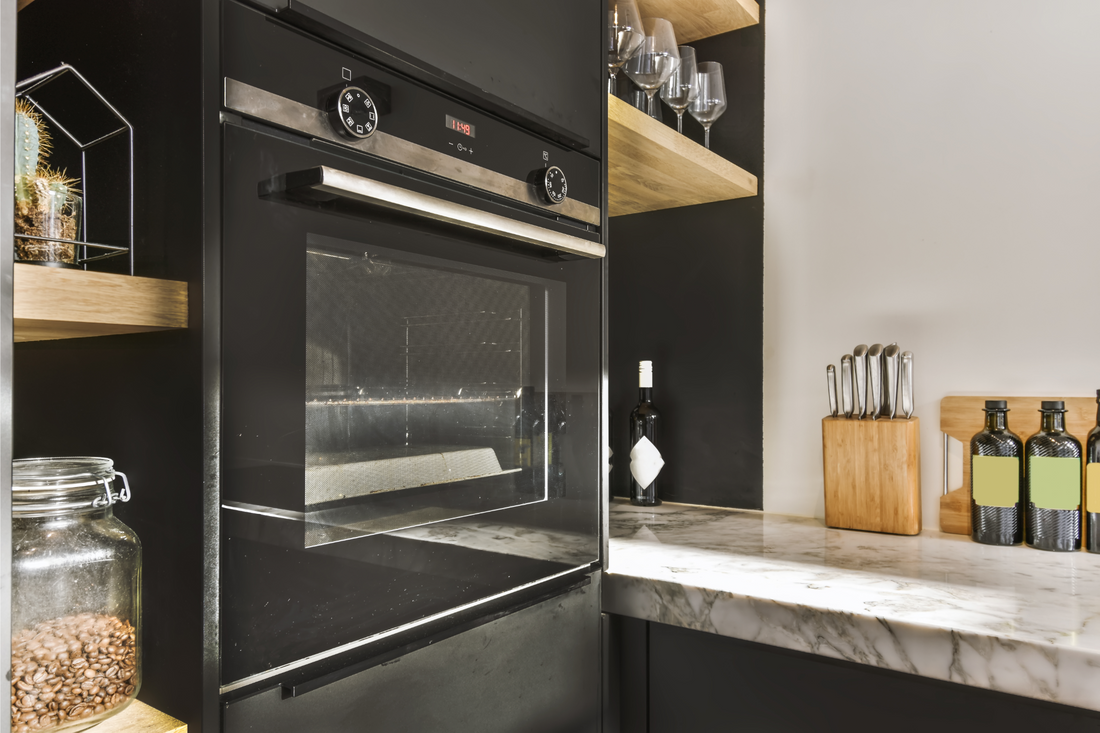 Contemporaty kitchen oven, clean countertops, wine glasses, kitchen utensils and tools.