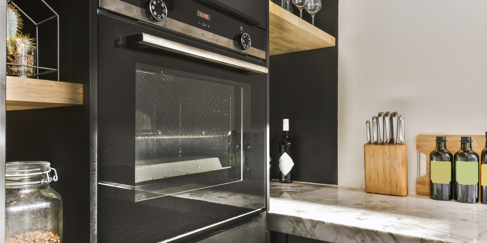 Contemporaty kitchen oven, clean countertops, wine glasses, kitchen utensils and tools.