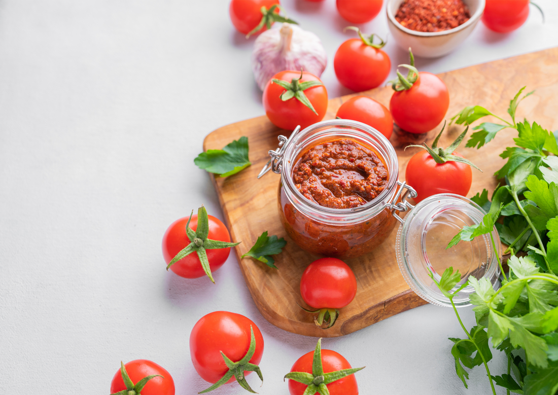 Traditional Mexican sauce Salsa with tomatoes and hot peppers on a light background with fresh herbs. Vegetarian food. Top view and copy space.