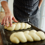 Pastry-chef making buns from dough. Making bread from scratch. Homemade bread.