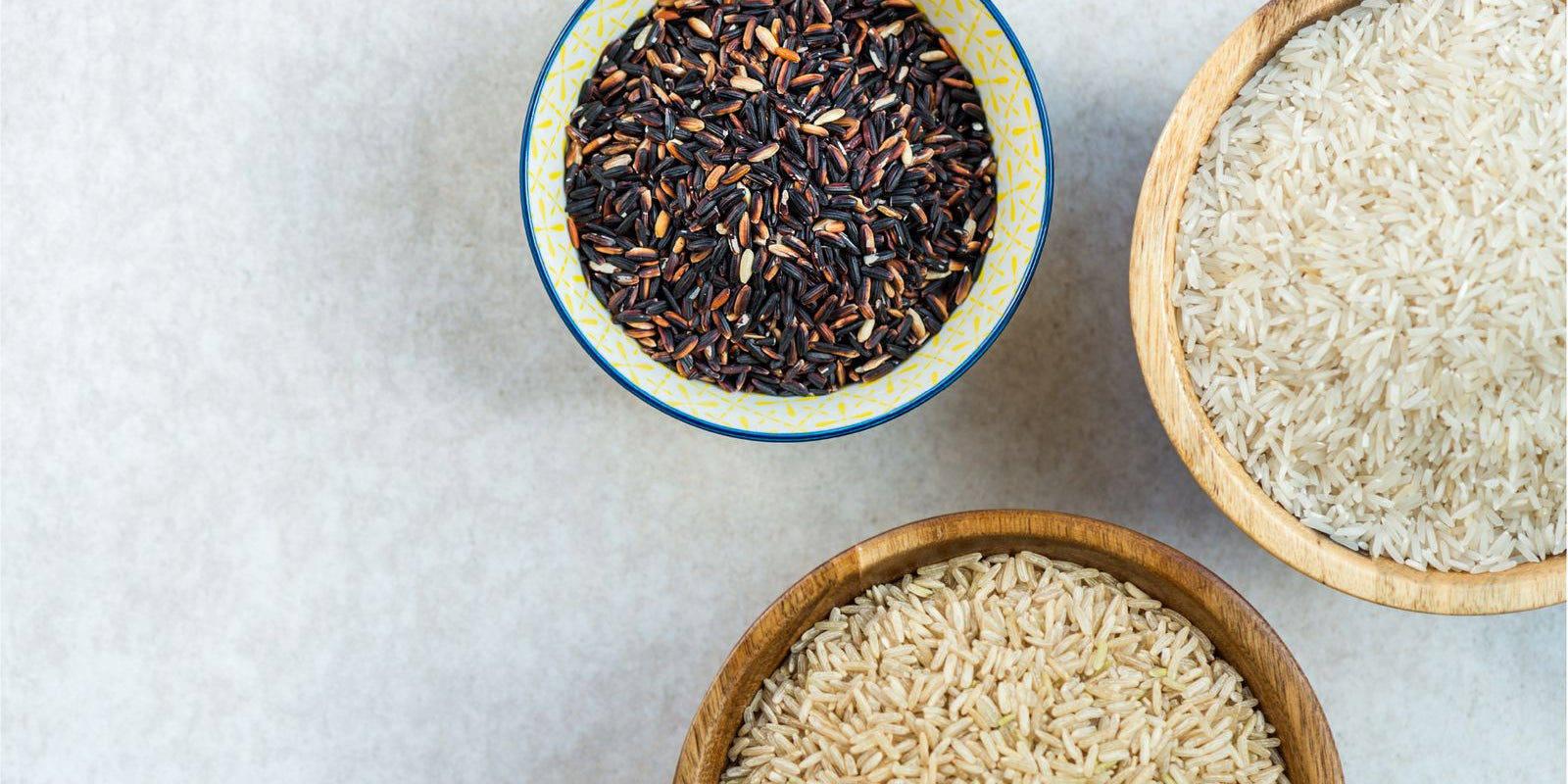 bowls of uncooked rice in a white countertop, minimalist