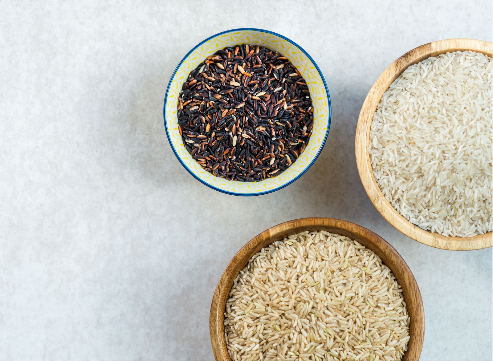 bowls of uncooked rice in a white countertop, minimalist