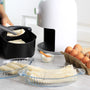 Cooking Process Using White Air Fryer for Healthy Cooking in the Kitchen. Woman Hand Put Fritters Lumpia to the Air Fryer Tray