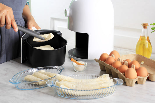 Cooking Process Using White Air Fryer for Healthy Cooking in the Kitchen. Woman Hand Put Fritters Lumpia to the Air Fryer Tray
