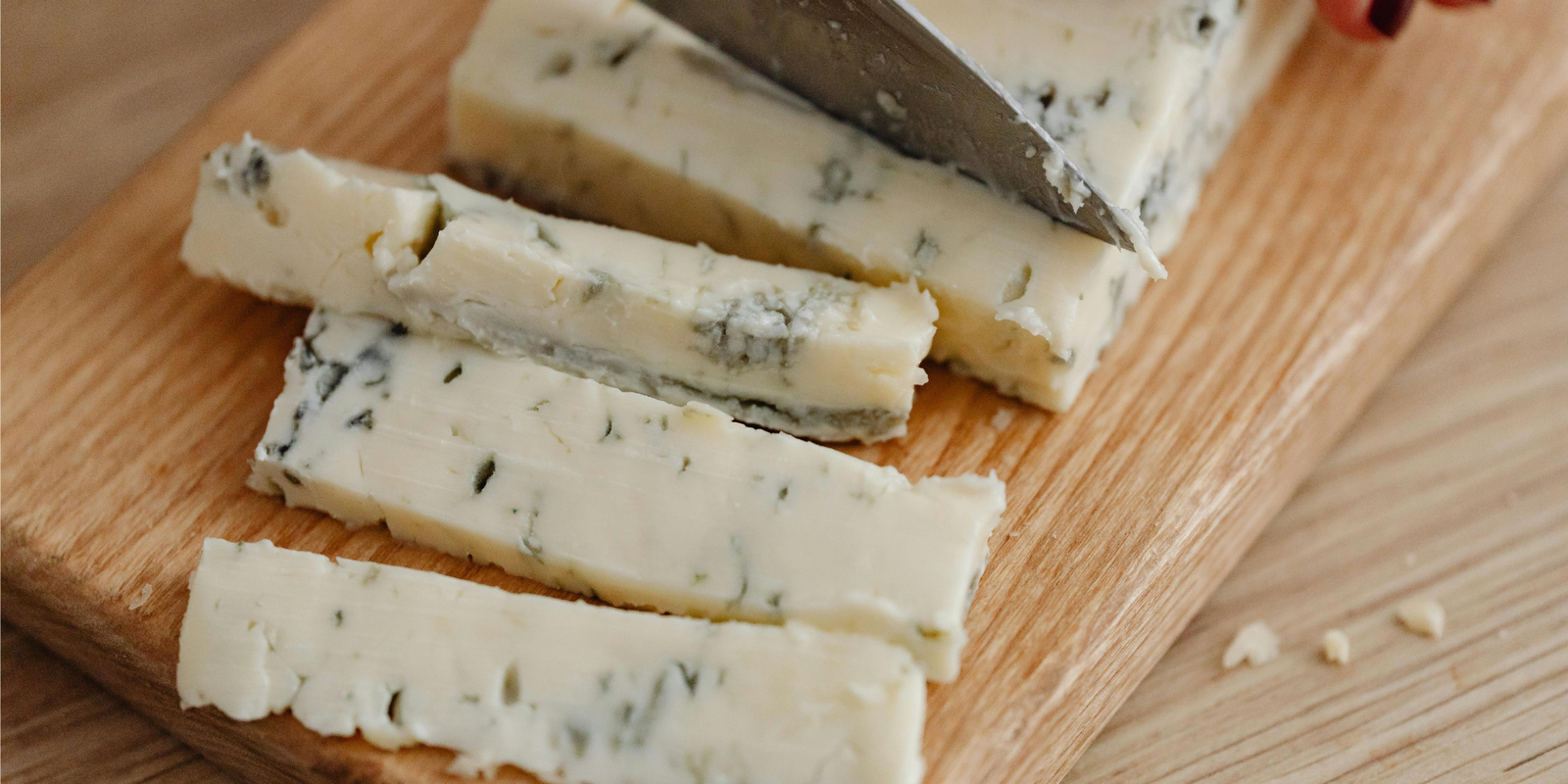 cutting blue cheese in cutting board