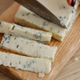 cutting blue cheese in cutting board