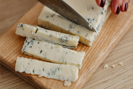 cutting blue cheese in cutting board