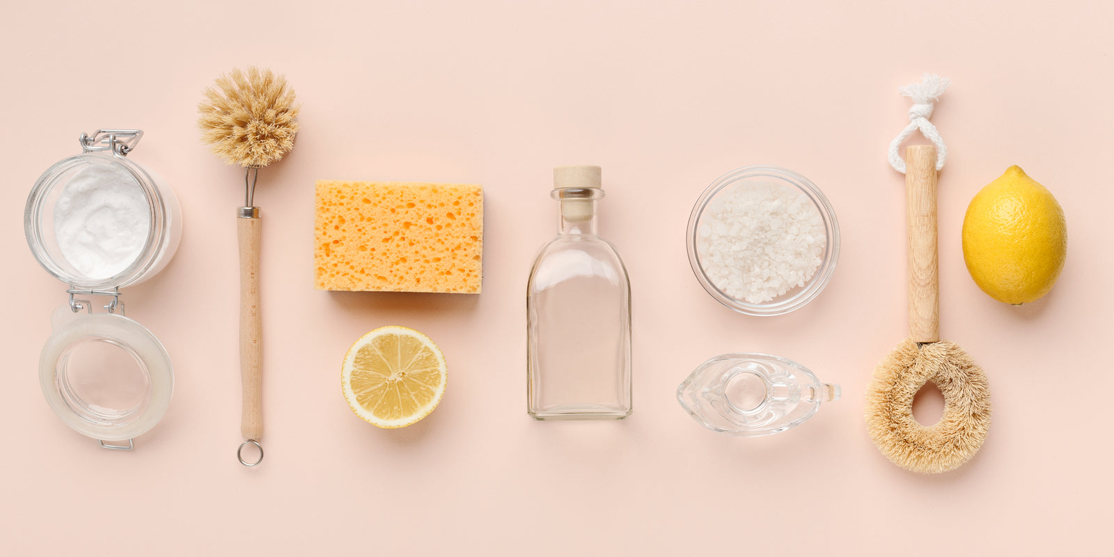 Flat lay composition with eco-friendly natural cleaners. Baking soda, salt, lemon, bamboo brushes on pink background, panorama