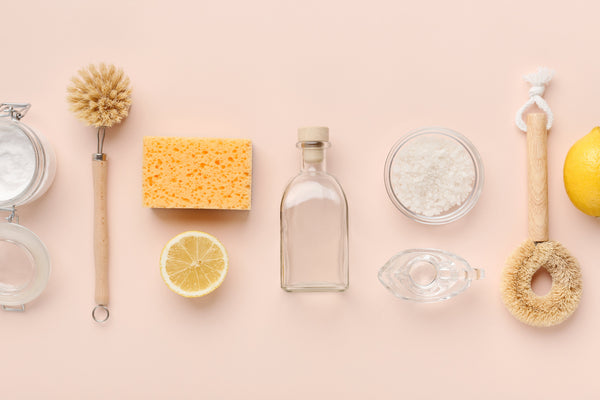 Flat lay composition with eco-friendly natural cleaners. Baking soda, salt, lemon, bamboo brushes on pink background, panorama