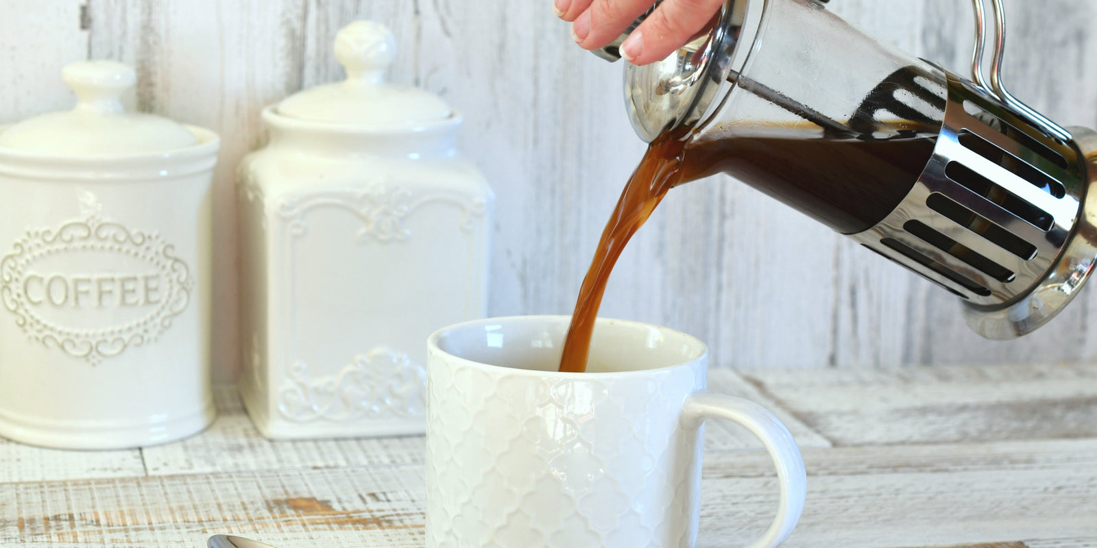 Pouring coffee from a French press coffee maker into a white mug. Morning ritual, drinking coffee, bright and airy lifestyle. 