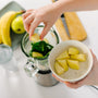 Girl making healthy drink. Ingredients for green healthy smoothie - bananas, apples, spinach and water