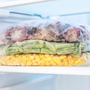 Shelf with frozen food in the refrigerator close up front view