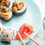 Sushi rolls in blue plate, chopsticks and soy sauce