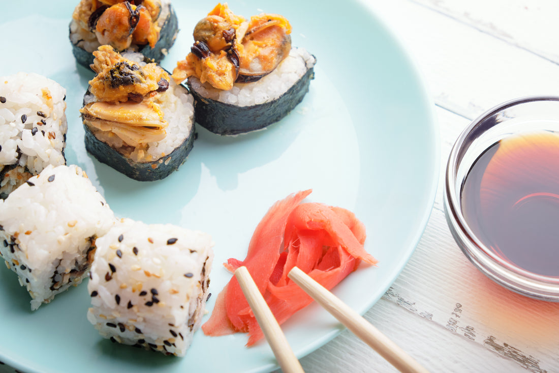 Sushi rolls in blue plate, chopsticks and soy sauce